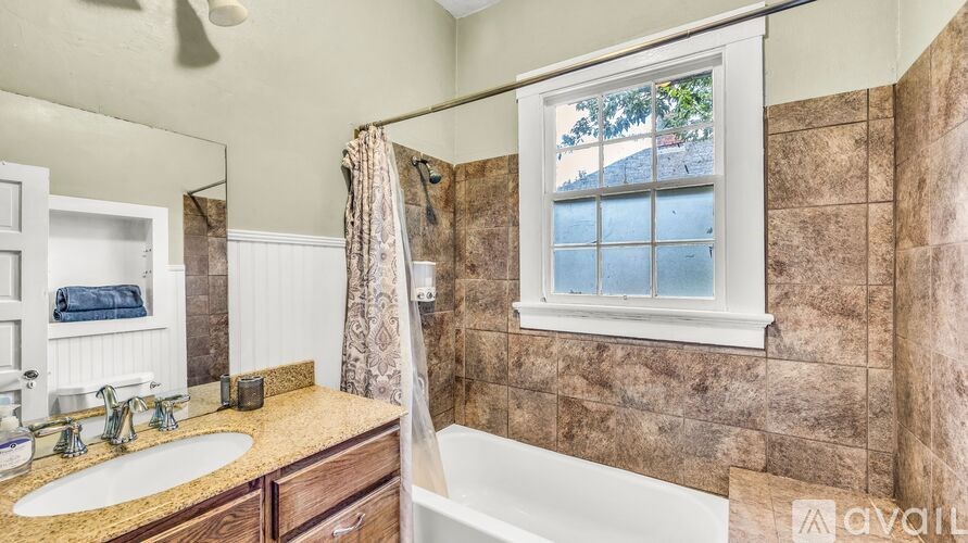 A bathroom with a window showing a view of a house.