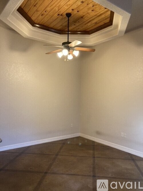 A room with a ceiling fan and tile flooring.