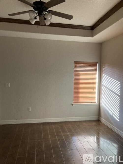 A room with a ceiling fan and a window with blinds.