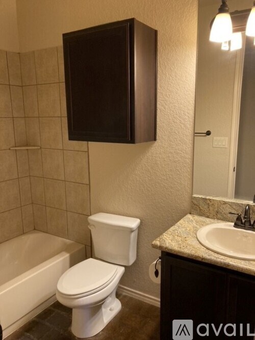 A white toilet sits next to a bathtub in a bathroom.