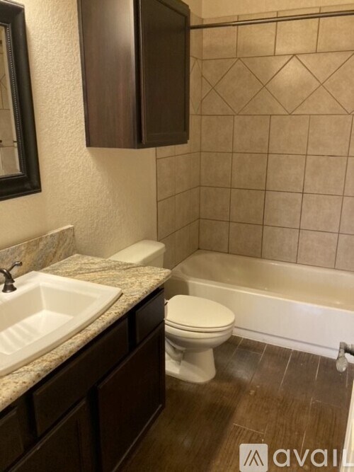 A bathroom with a sink, toilet, and bathtub.