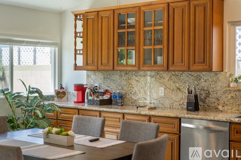 A kitchen with wooden cabinets and a marble countertop.