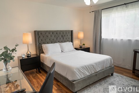 A bedroom with a large bed and a chair.