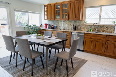 A kitchen with a table and chairs in front of it.