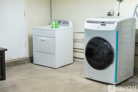 A white dryer and washing machine are in a room.