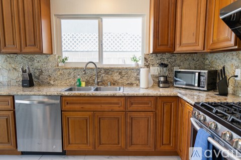 A kitchen with wooden cabinets and a stainless steel dishwasher.