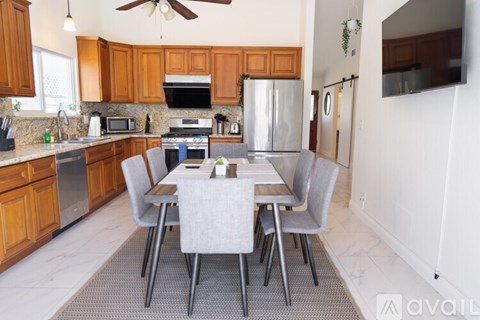 A kitchen with a table and chairs in front of it.