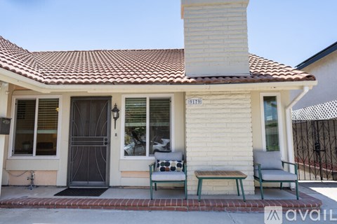 A house with a white exterior and a black door is for sale.