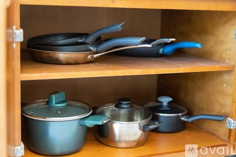 A kitchen shelf with pots and pans on it.