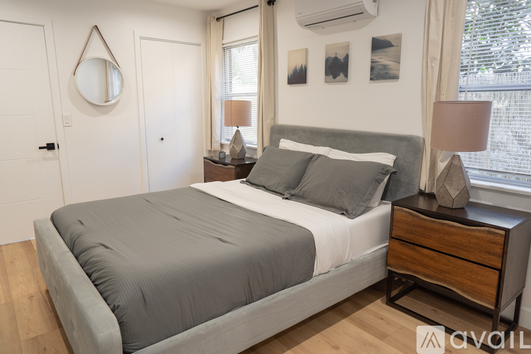 A bedroom with a bed, nightstand, and lamp.
