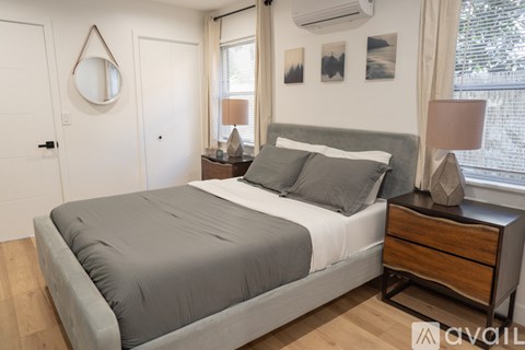 A bedroom with a bed, nightstand, and lamp.