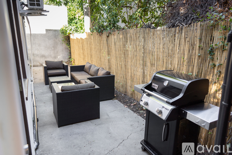 A patio with a grill and seating area.