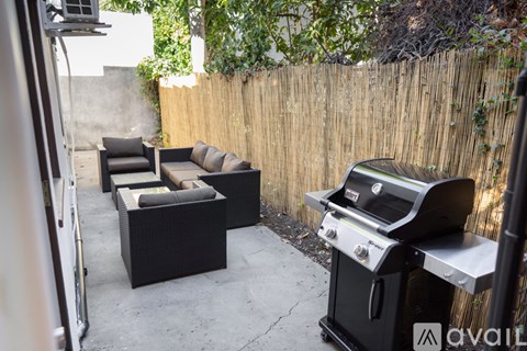 A patio with a grill and seating area.