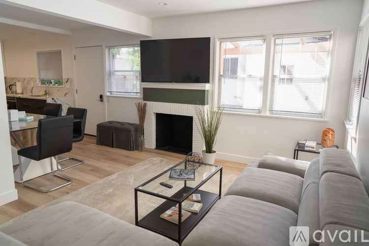 A living room with a grey couch and a fireplace.