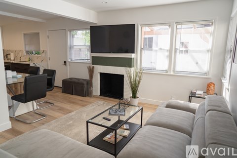 A living room with a grey couch and a fireplace.
