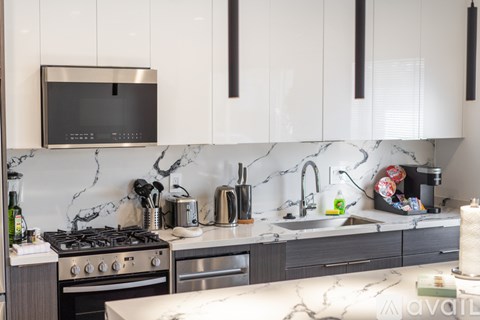 A kitchen with a black microwave above the stove.