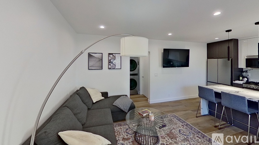 A living room with a grey couch and a white chair.
