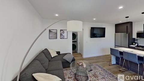 A living room with a grey couch and a white chair.