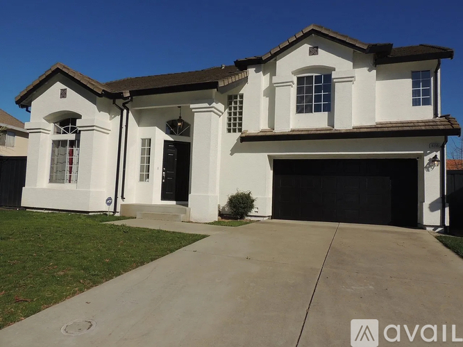 A two-story house with a garage is available for sale.