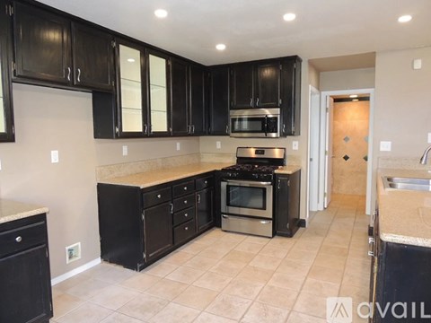 A kitchen with black cabinets and a stove top oven.