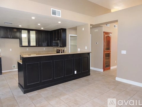 A kitchen with black cabinets and a countertop is available for rent.