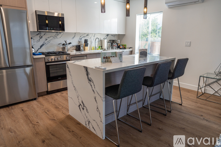 A kitchen with a marble island and modern appliances.