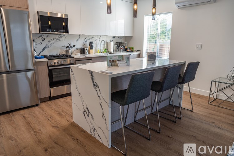 A kitchen with a marble island and modern appliances.