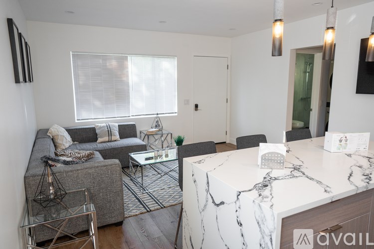 A modern living room with a grey sofa, a white coffee table, and a marble countertop.