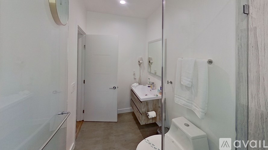 A bathroom with a toilet, sink, and mirror.