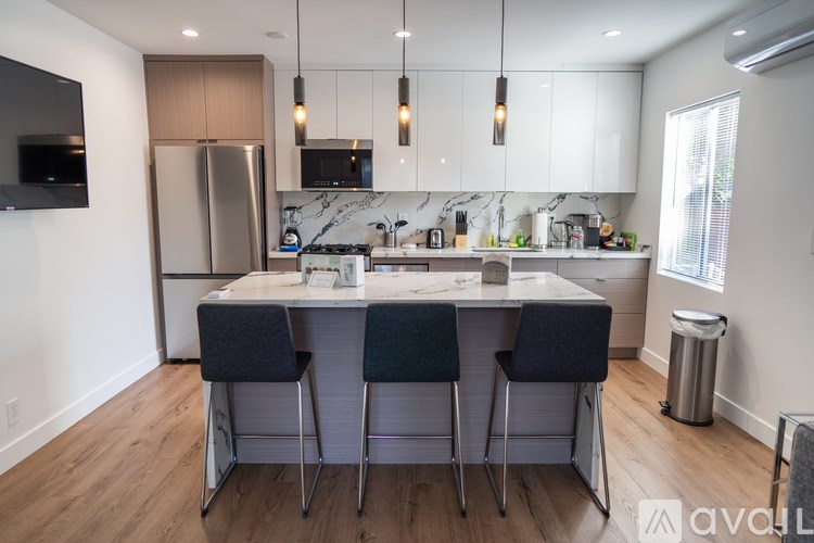 A modern kitchen with a center island and bar stools.