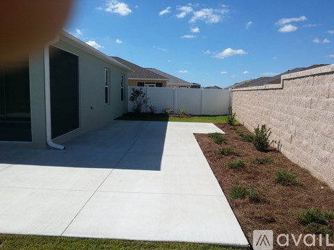 A sunny day in a residential area with houses and a fence.