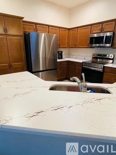 A kitchen with a marble countertop and stainless steel appliances.