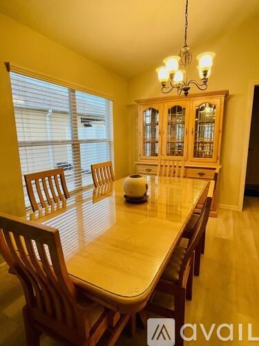 A dining room with a wooden table and chairs.