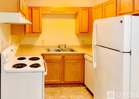 A kitchen with a white stove and refrigerator.