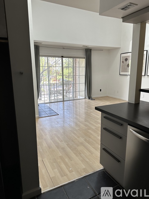 A kitchen with a black counter top and wooden flooring.