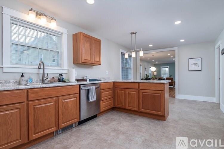 A kitchen with wooden cabinets and a large window.