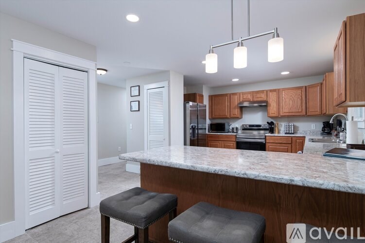 A kitchen with a marble countertop and wooden cabinets.