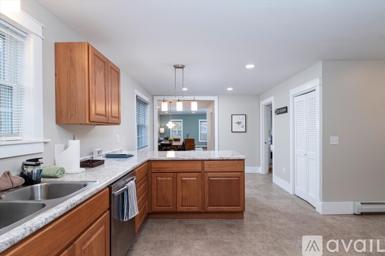 A kitchen with wooden cabinets and a marble countertop.