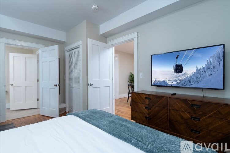 A bedroom with a large bed and a television displaying a ski lift.