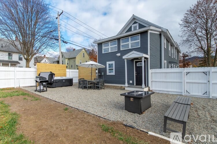 A house with a grey exterior and a white fence.