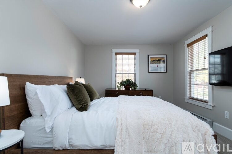 A bedroom with a large bed and a flat screen TV mounted on the wall.