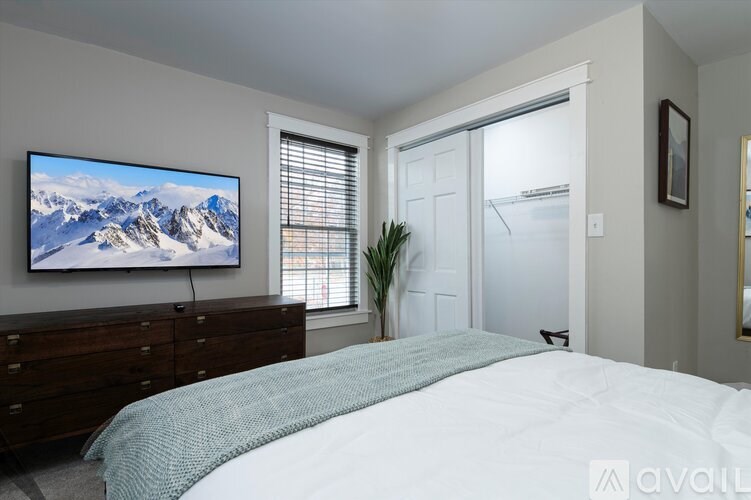 A bedroom with a large bed and a mountain scene on the wall.