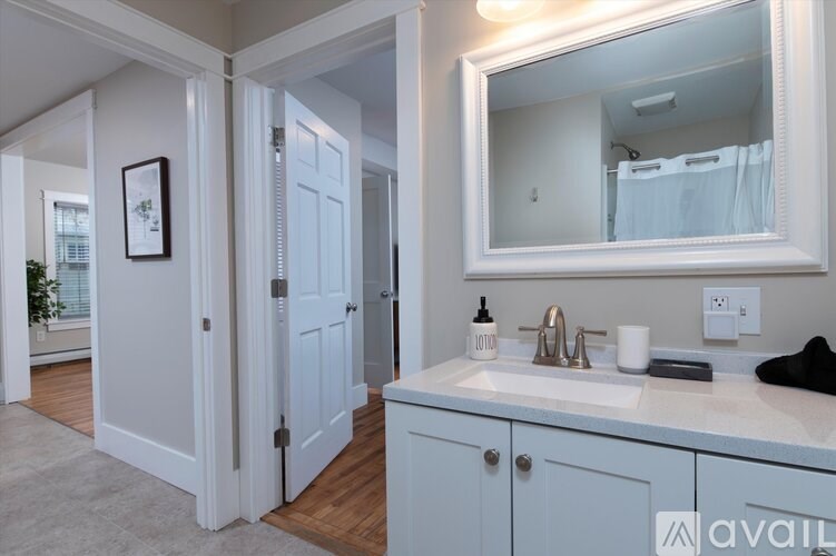 A bathroom with a white sink and a large mirror.