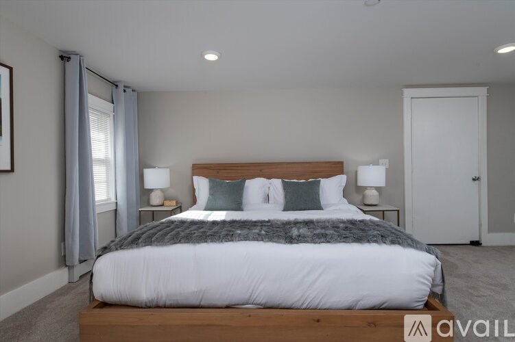 A bedroom with a large bed and a wooden headboard.
