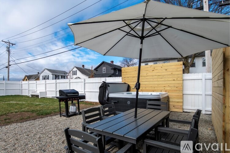 A patio with a table, chairs, and an umbrella is set up.