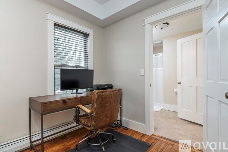 A room with a desk and chair in it.