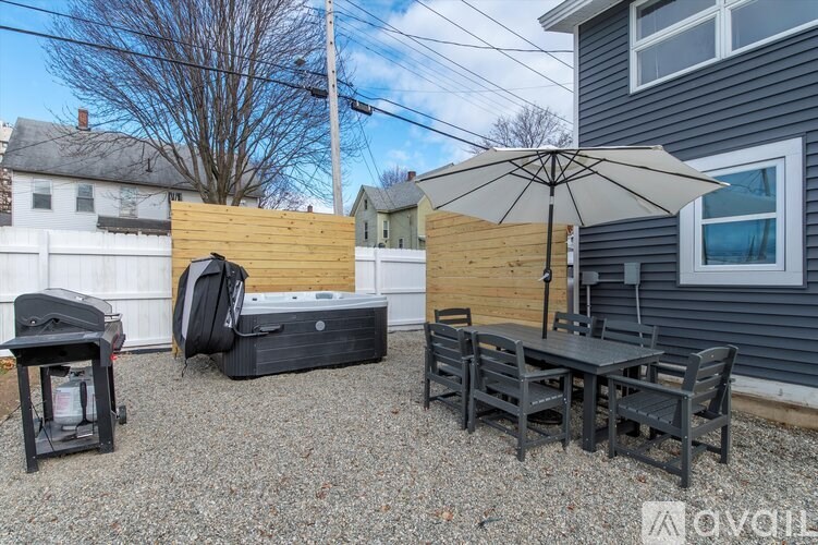A patio with a table, chairs, and an umbrella is set up.