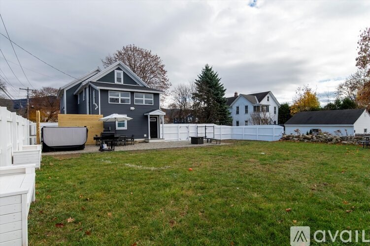 A house with a grey roof and a white fence is shown.