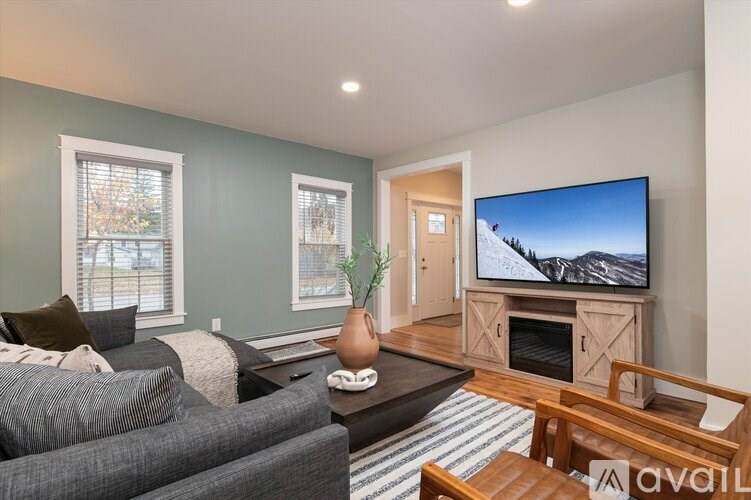 A living room with a grey couch and a television on a wooden stand.