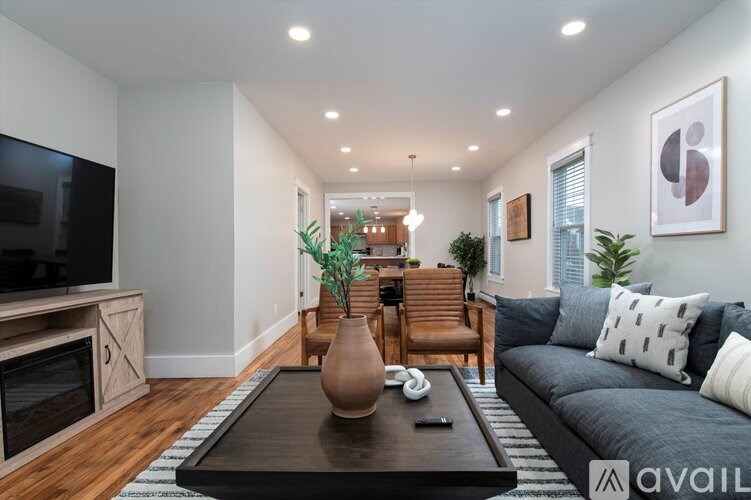 A living room with a grey couch, a wooden coffee table, and a television.